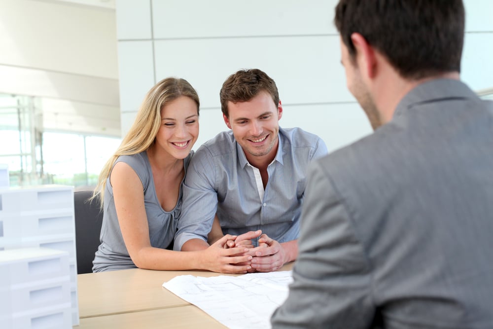Couple in real-estate agency talking to construction planner
